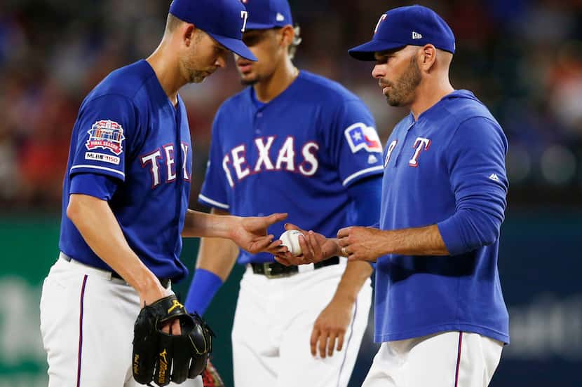 Texas Rangers manager Chris Woodward (8) pulls Texas Rangers starting pitcher Mike Minor...