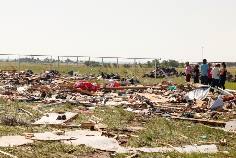 A family sits by their destroyed house, on Sunday, May 26, 2024, in Valley View, after a...