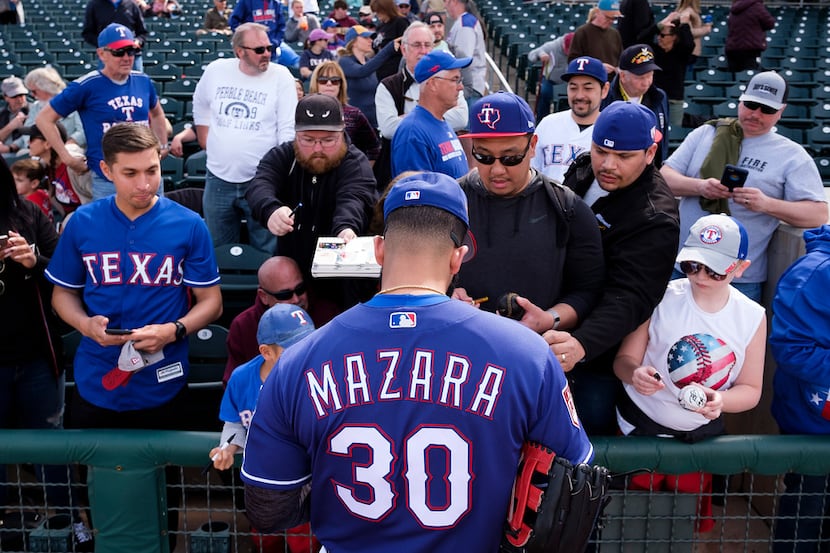Texas Rangers outfielder Nomar Mazara signs autographs before a spring training baseball...