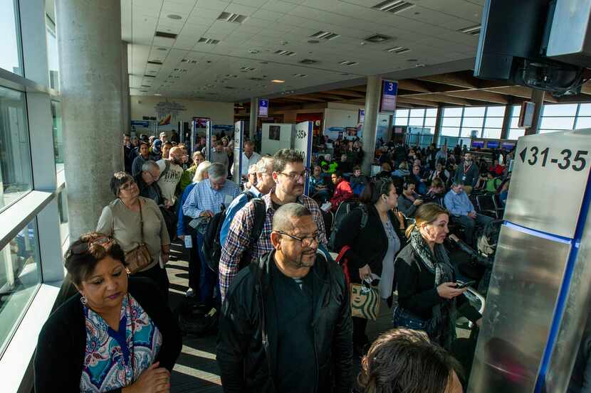 Travelers line up to board a flight at the Dallas Love Field airport on Thursday, Nov. 14,...