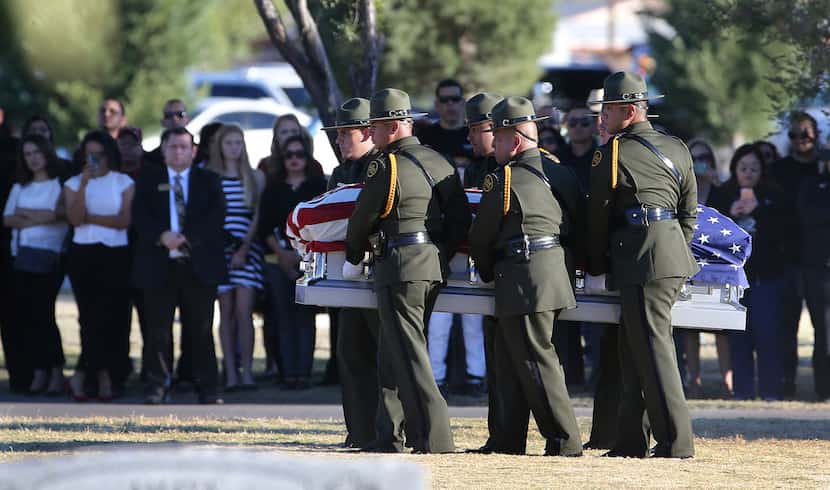 Border Patrol pallbearers carry Border Patrol agent Rogelio Martinez to a graveside service...