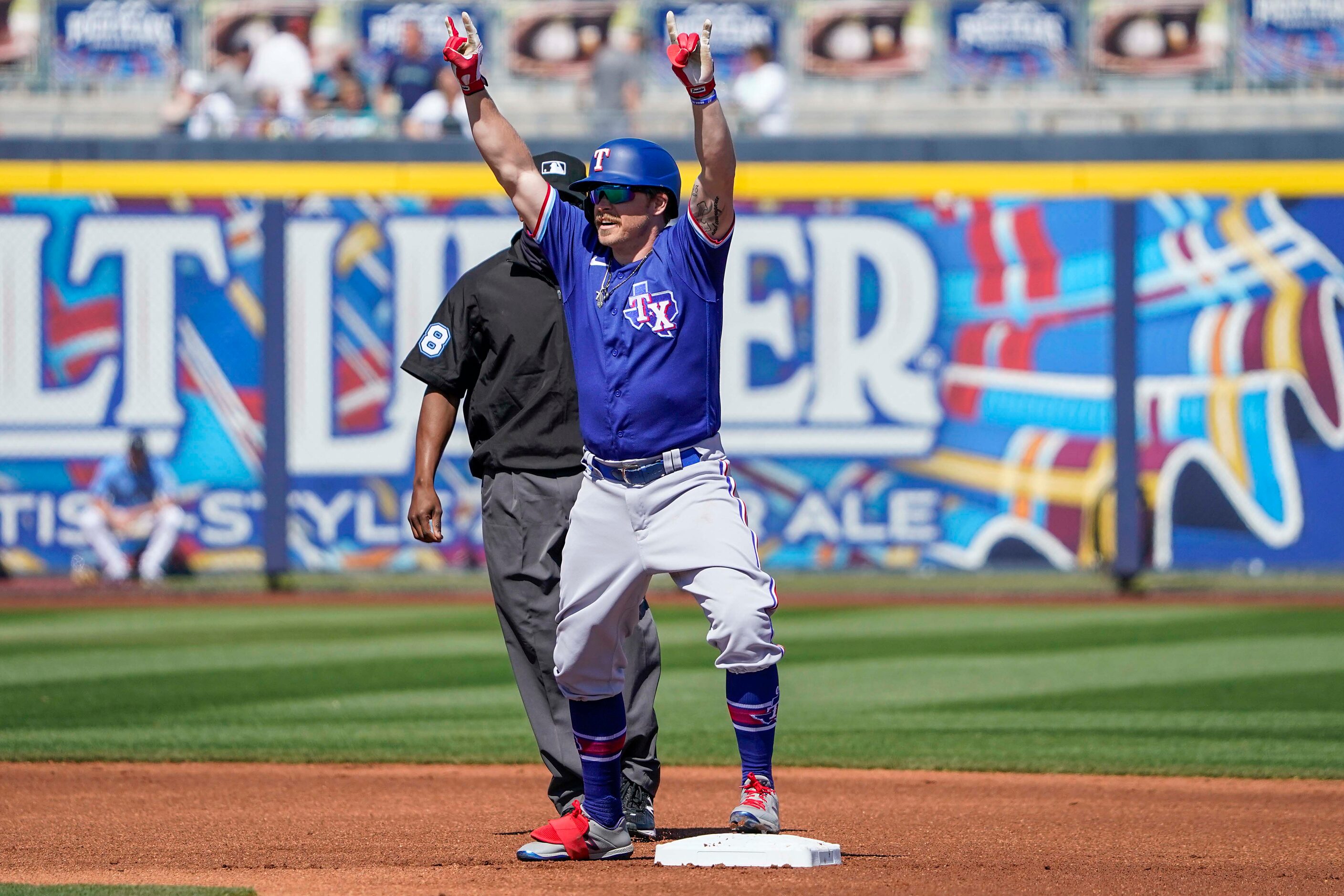 Texas Rangers infielder Brock Holt celebrates at second base after hitting a leadoff double...