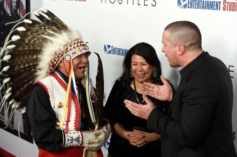 From left: Phillip Whiteman Jr., Lynette Two Bulls and Christian Bale talk on the red carpet...