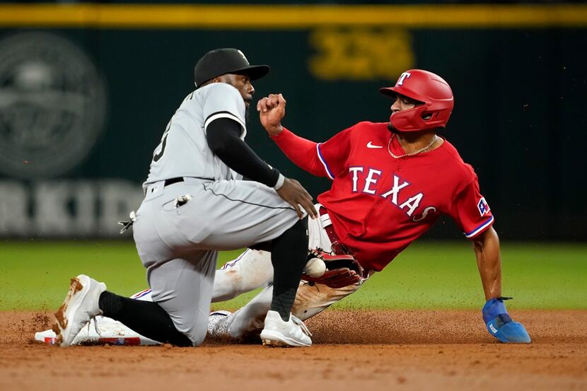 Chicago White Sox' Josh Harrison tries to catch the throw as Texas Rangers' Bubba Thompson...