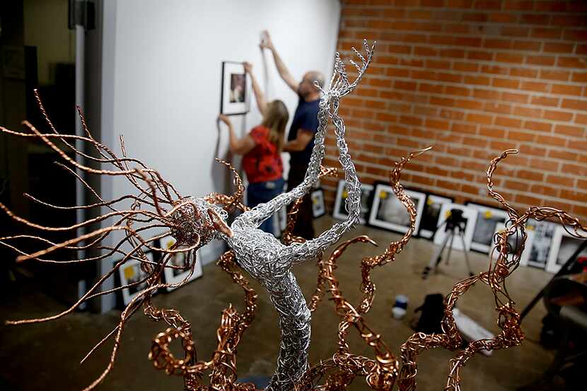 Tammy Cromer and Charles Arnold hang photographs in the new Tammy Cromer Photo/Sculpture...