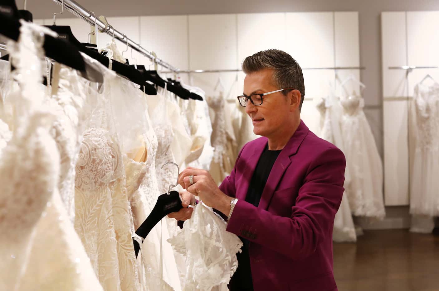 Randy Fenoli adjusts a bridal dress at the Shops at Willow Bend's newest store, Chally...