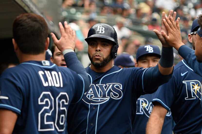 Tampa Bay Rays designated hitter Nelson Cruz, center, is congratulated by teammates after...