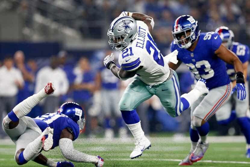 Dallas Cowboys running back Ezekiel Elliott (21) keep his feet under him as New York Giants...