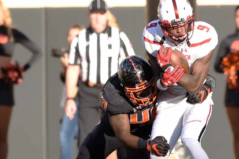 Texas Tech wide receiver Jonathan Giles (9) struggles against a tackle from Oklahoma State...