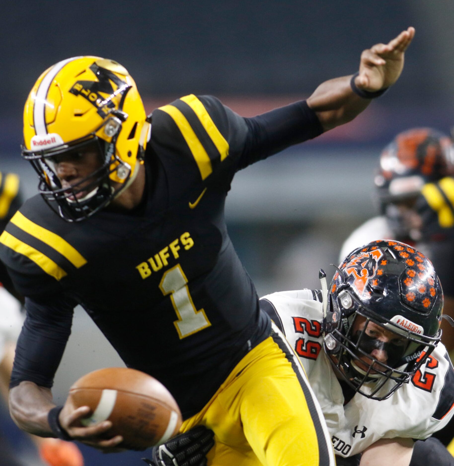 Fort Bend Marshall quarterback Malik Hornsby (1) spins in the backfield to elude the...