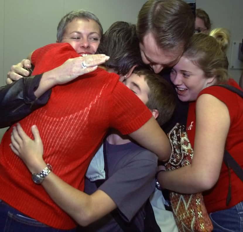 Shannon Brame, top left, and her children Josh, 12, and Rebecca, 14, right, are hugged by...