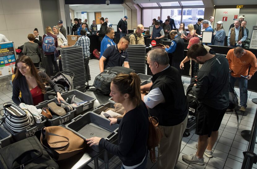 Travelers passed through a TSA security entrance in Terminal C at DFW International Airport...