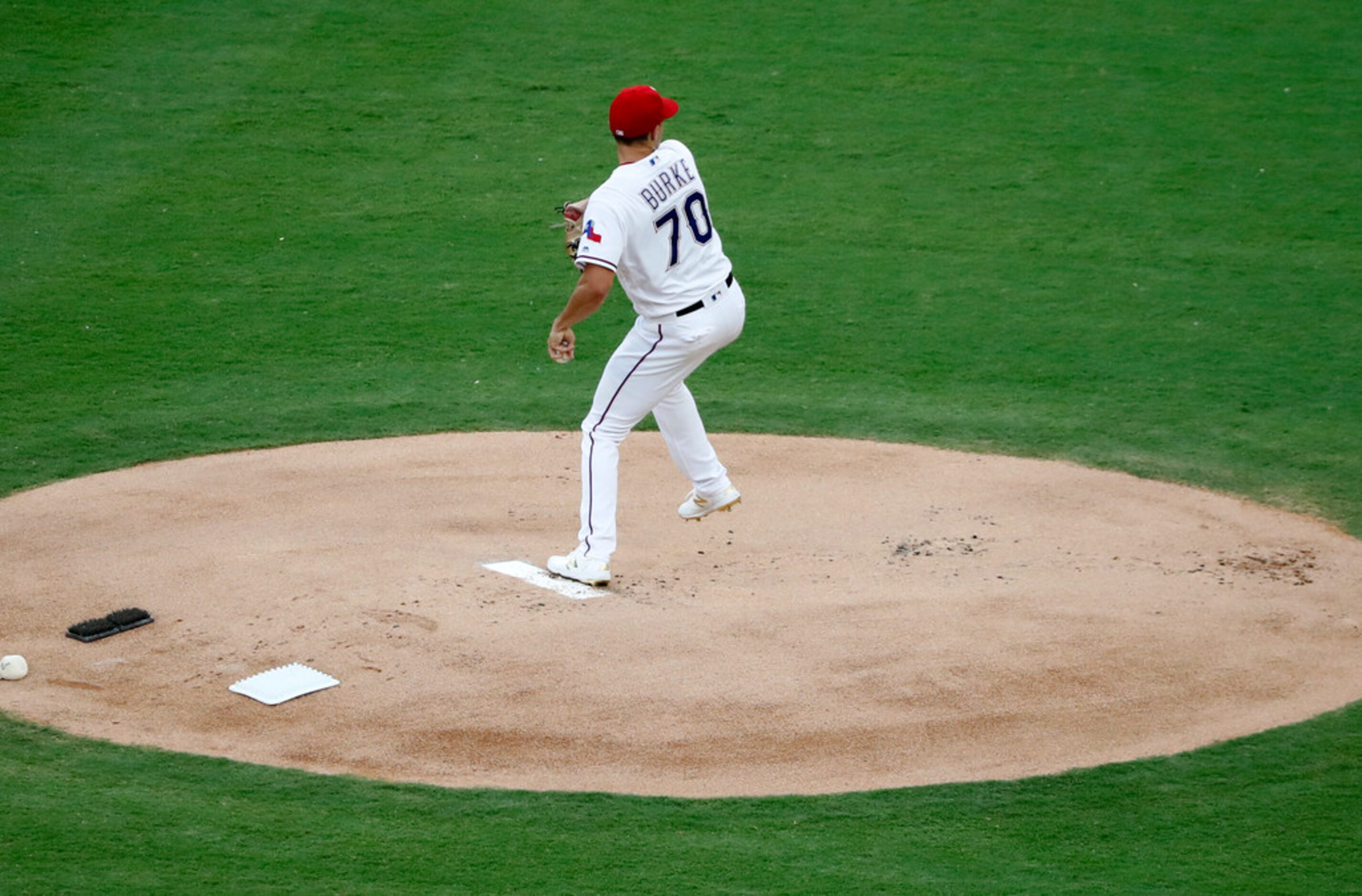 Texas Rangers starting pitcher Brock Burke throws to the Oakland Athletics in the first...