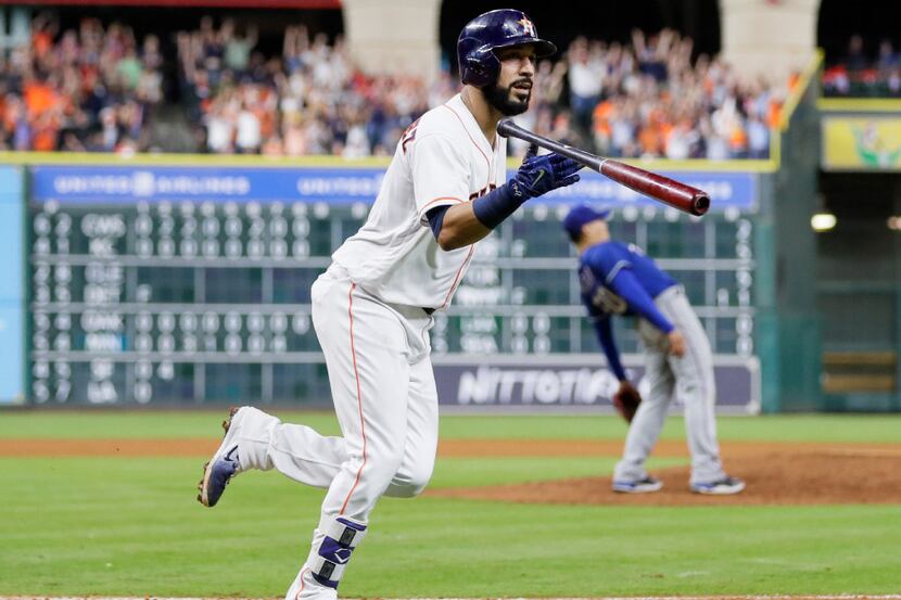 Houston Astros' Marwin Gonzalez tosses his bat after hitting a grand slam off Texas Rangers...