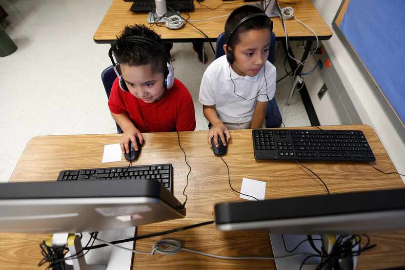 Second graders William Rios (left) and Jose Ramirez work on a debugging lesson during a...