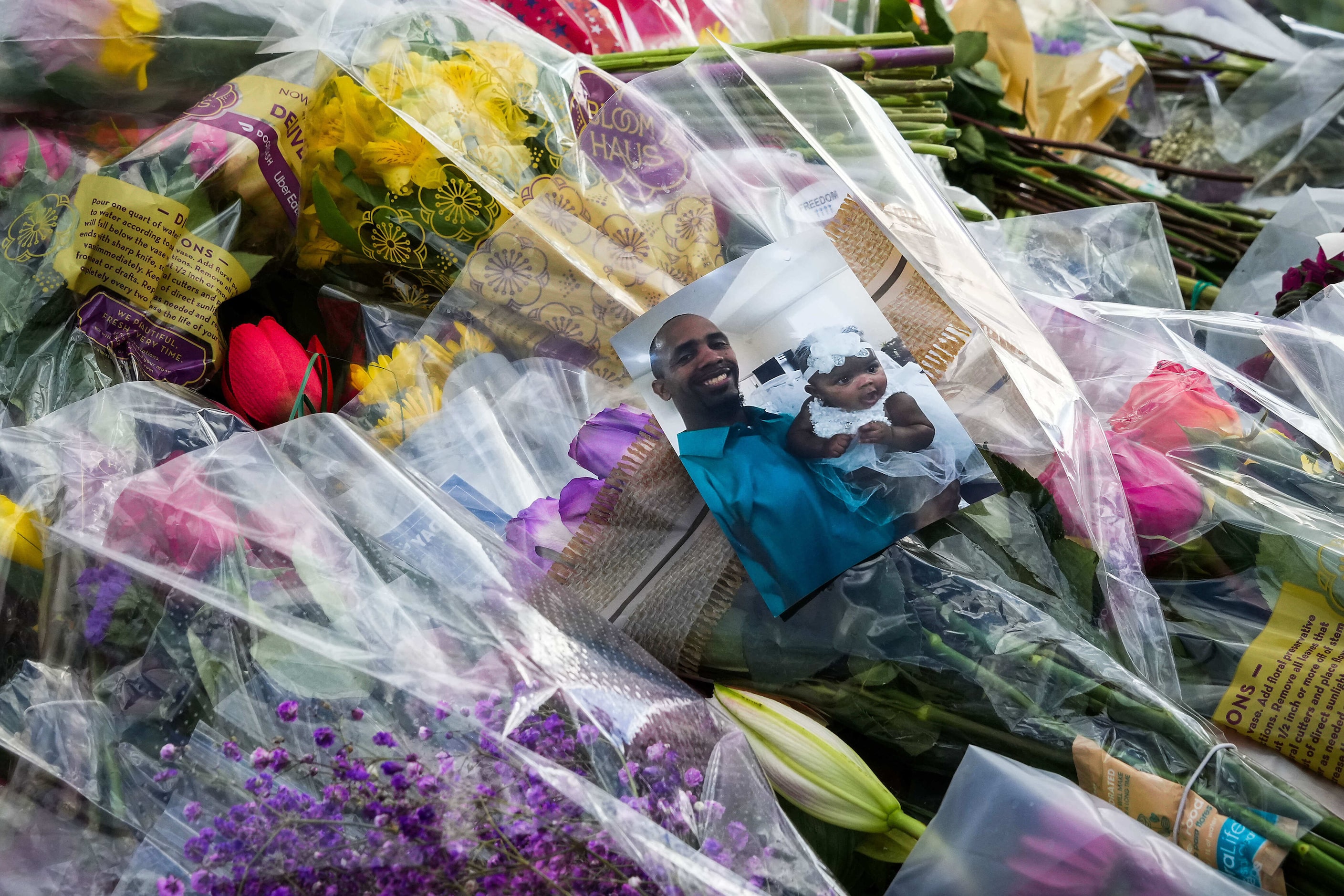 A pile of flowers covers a Dallas police patrol car serving as a memorial to slain officer...