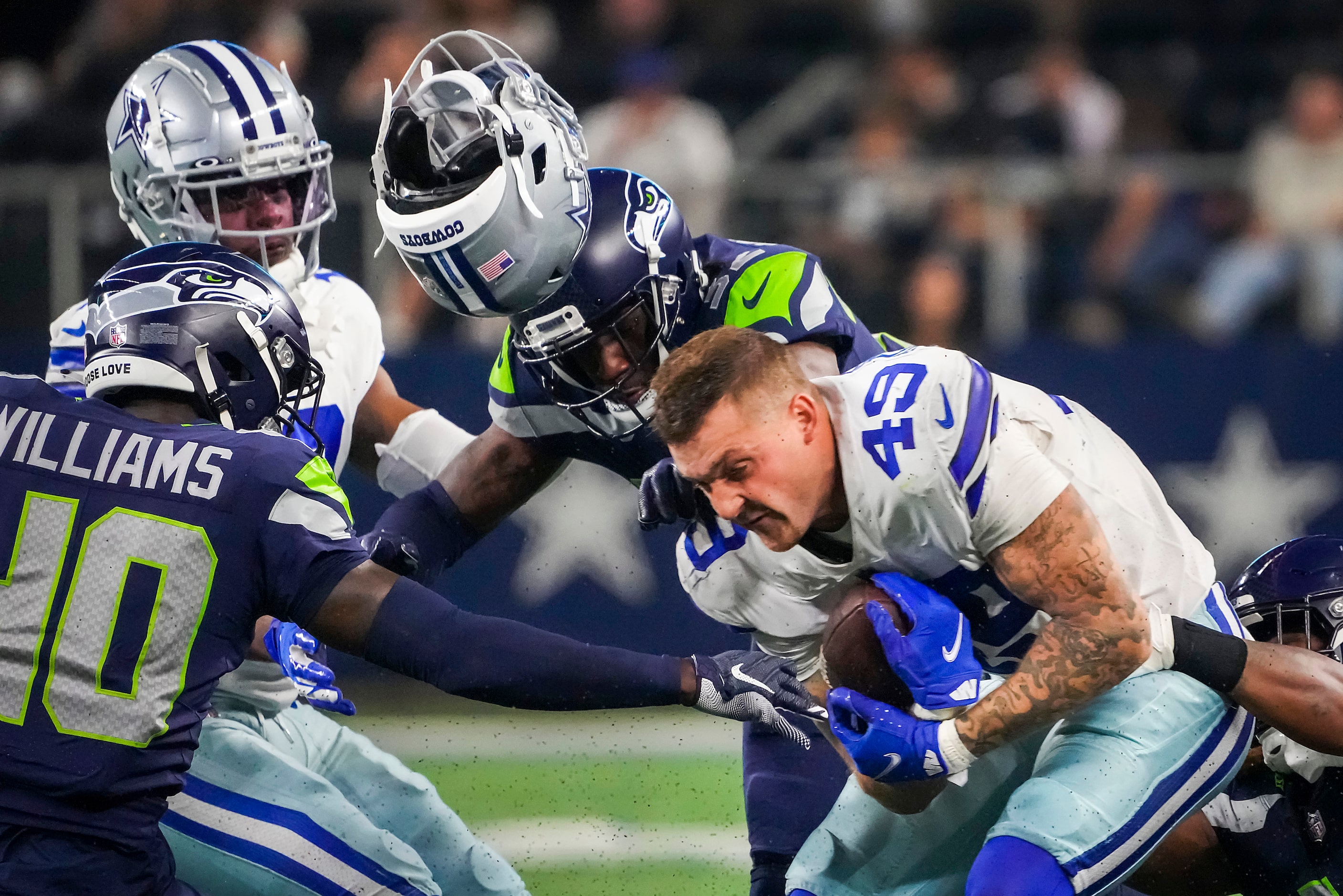 Dallas Cowboys tight end Peyton Hendershot (49) has his helmet knocked off on a hit by...