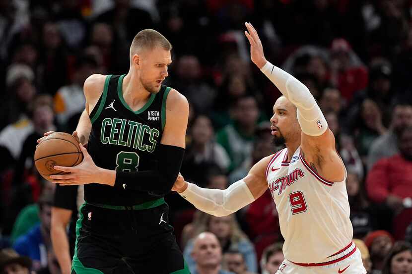Houston Rockets' Dillon Brooks (9) defends against Boston Celtics' Kristaps Porzingis (8)...
