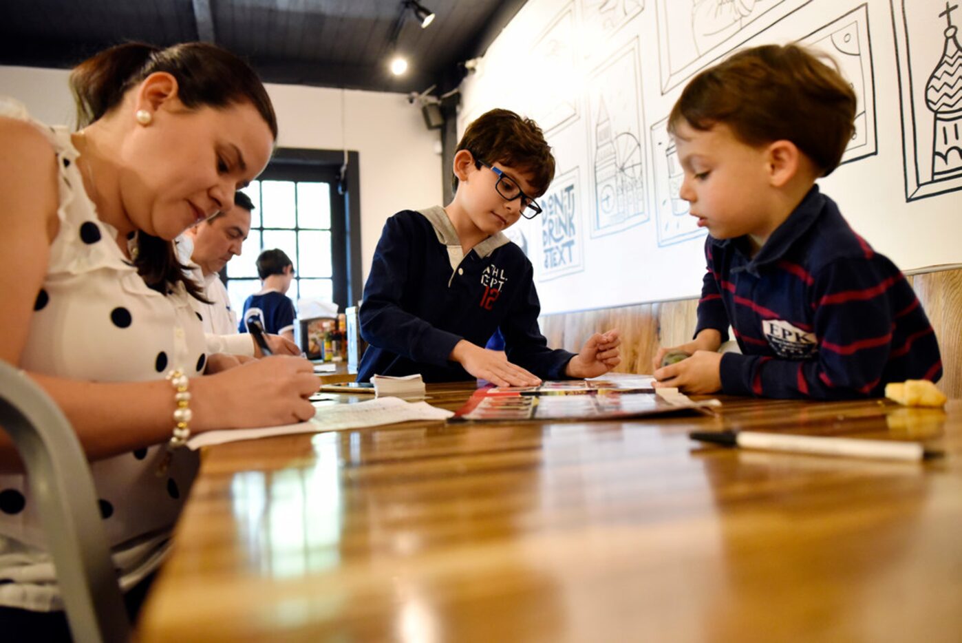 Juliana Rodriguez, left, works with her son Nicolas Lamus, 7, and Sebastian del Porto, 4, as...