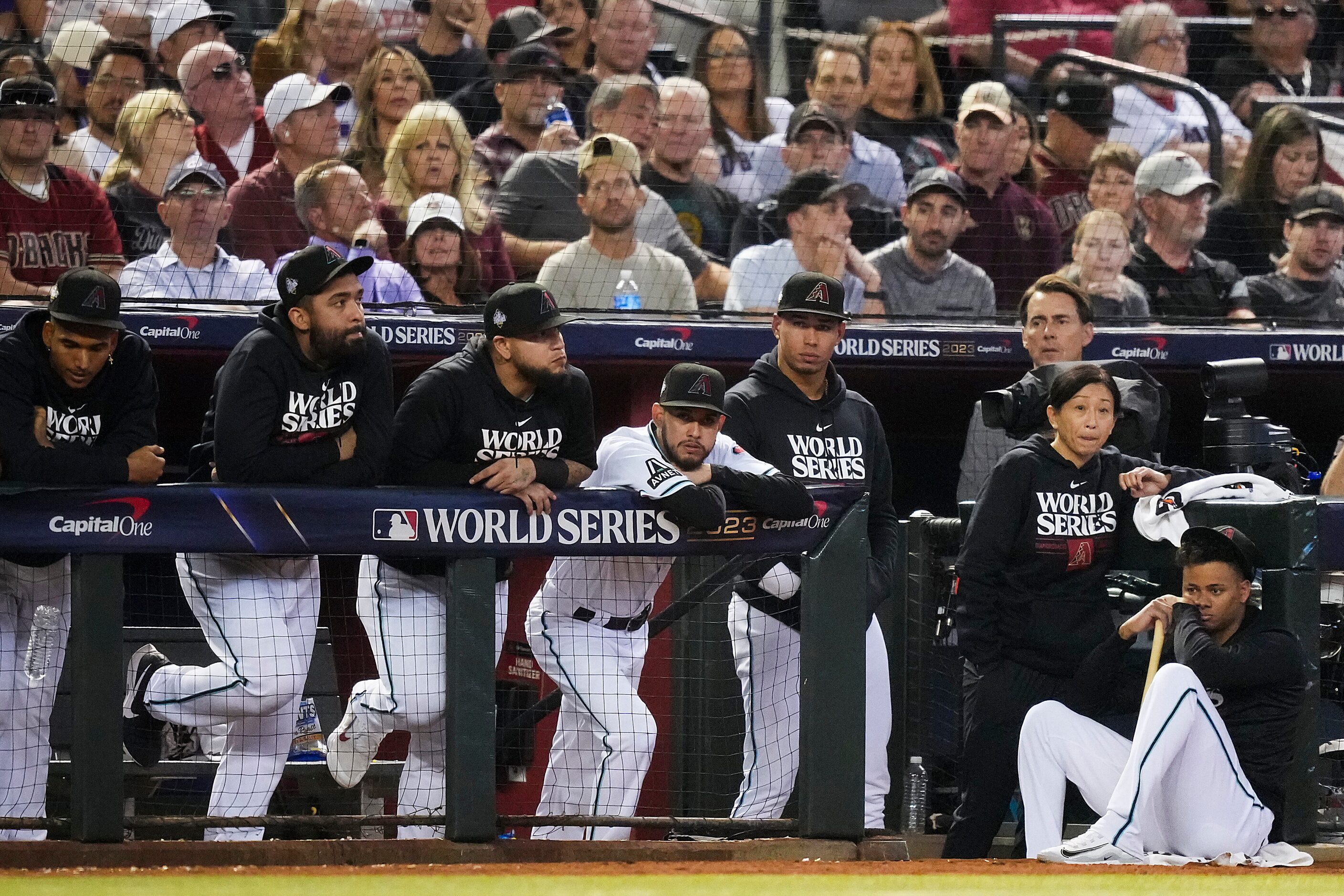 Players in the Arizona Diamondbacks dugout look on after a two-run home run by Texas Rangers...