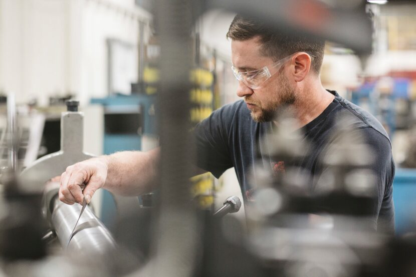 Mike Steffel, an apprentice toolmaker, works on a lathe at APT Manufacturing Solutions in...