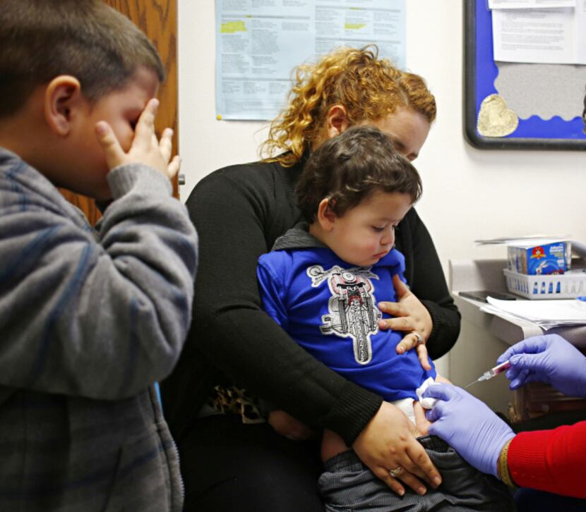 Six-year-old Errmer Rolon couldn’t watch as his little brother Bayron Rolon got a flu shot....