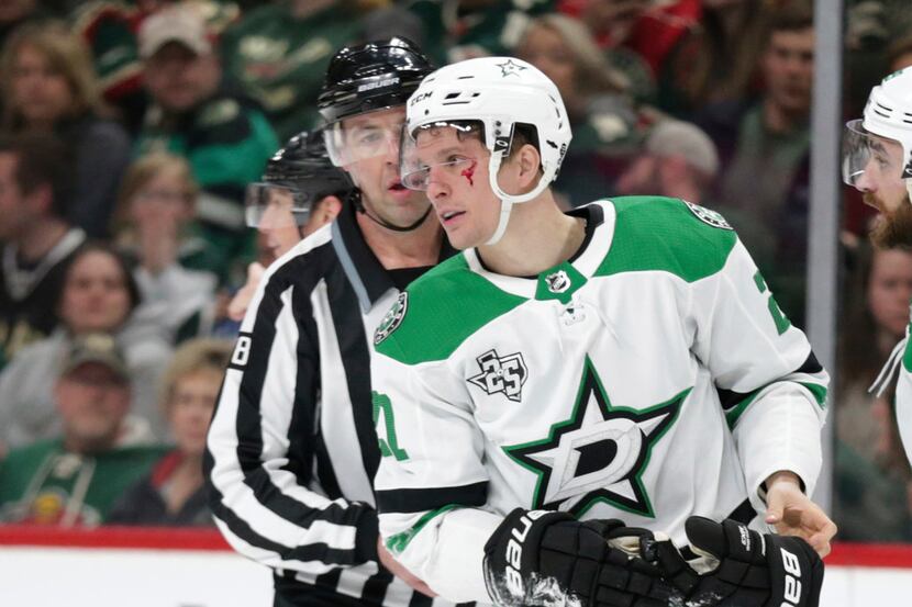 Dallas Stars left wing Antonie Roussel (21) skates off the ice with linesman Brian Mach (78)...