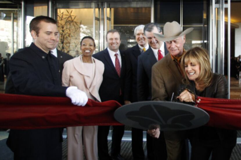 Linda Gray and Larry Hagman of TV's Dallas cut the ribbon to open the Omni Dallas on Friday....