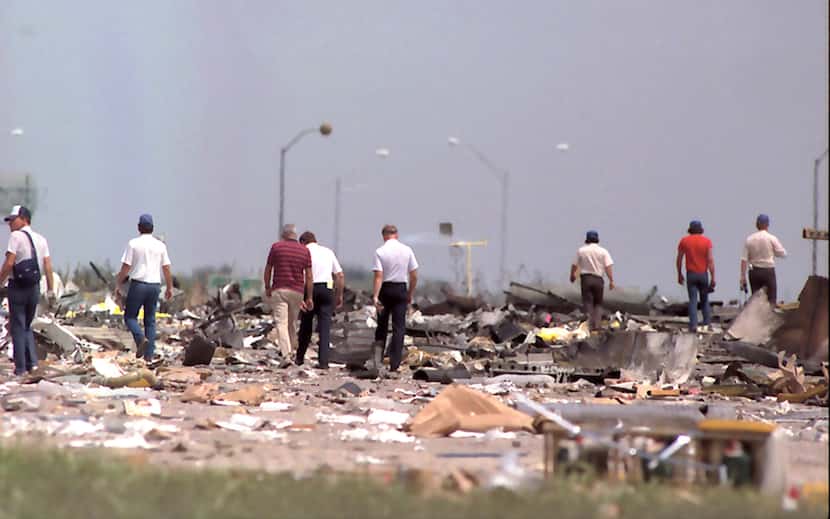 ORG XMIT: *S0413526130* 8/05/85 --- Rescue workers comb the site of the Delta crash at...