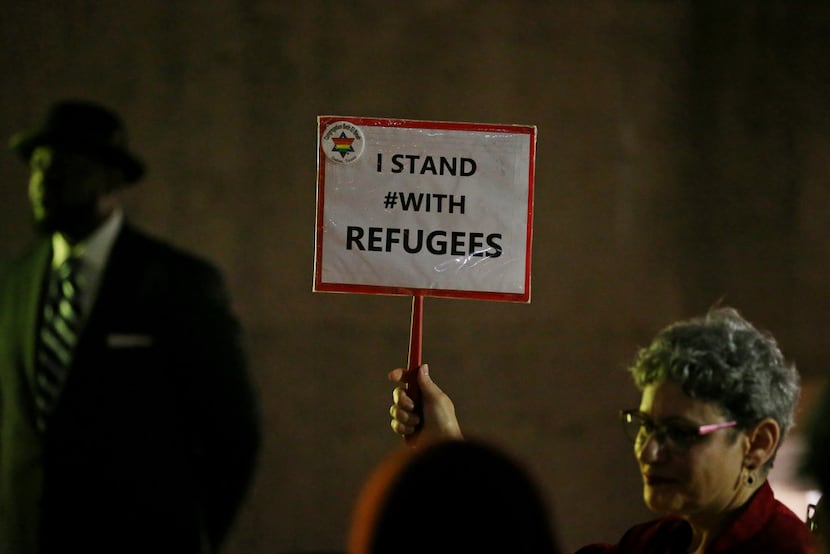 Linda Evans holds up a sign that reads "I STAND #WITH REFUGEES" during a protest among...