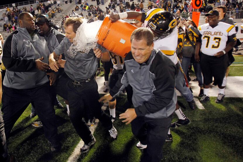 Garland head coach Jeff Jordan is doused with water following their win over Naaman Forest...