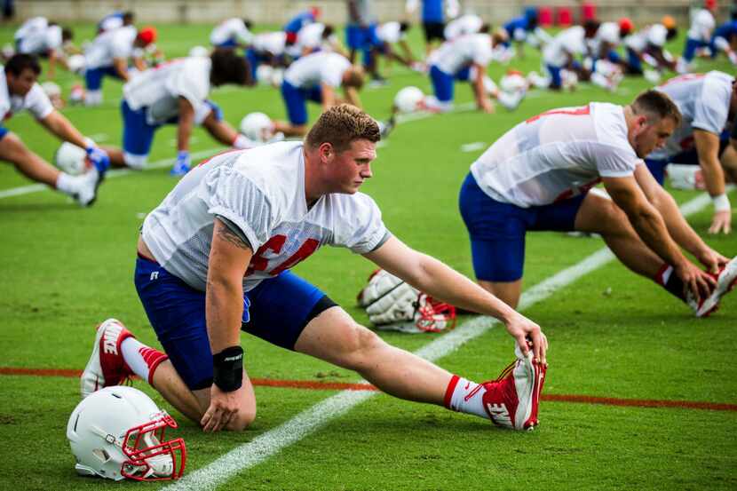 Offensive lineman Bryce Wilds (64) stretches during SMU's first football practice of the...