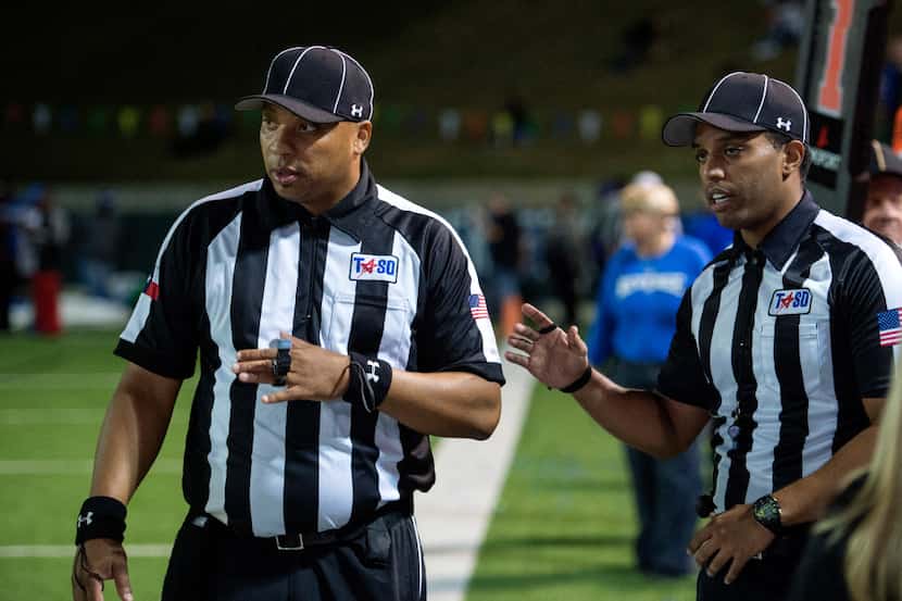 Referees confer on the sidelines in the fourth quarter of a high school football game...