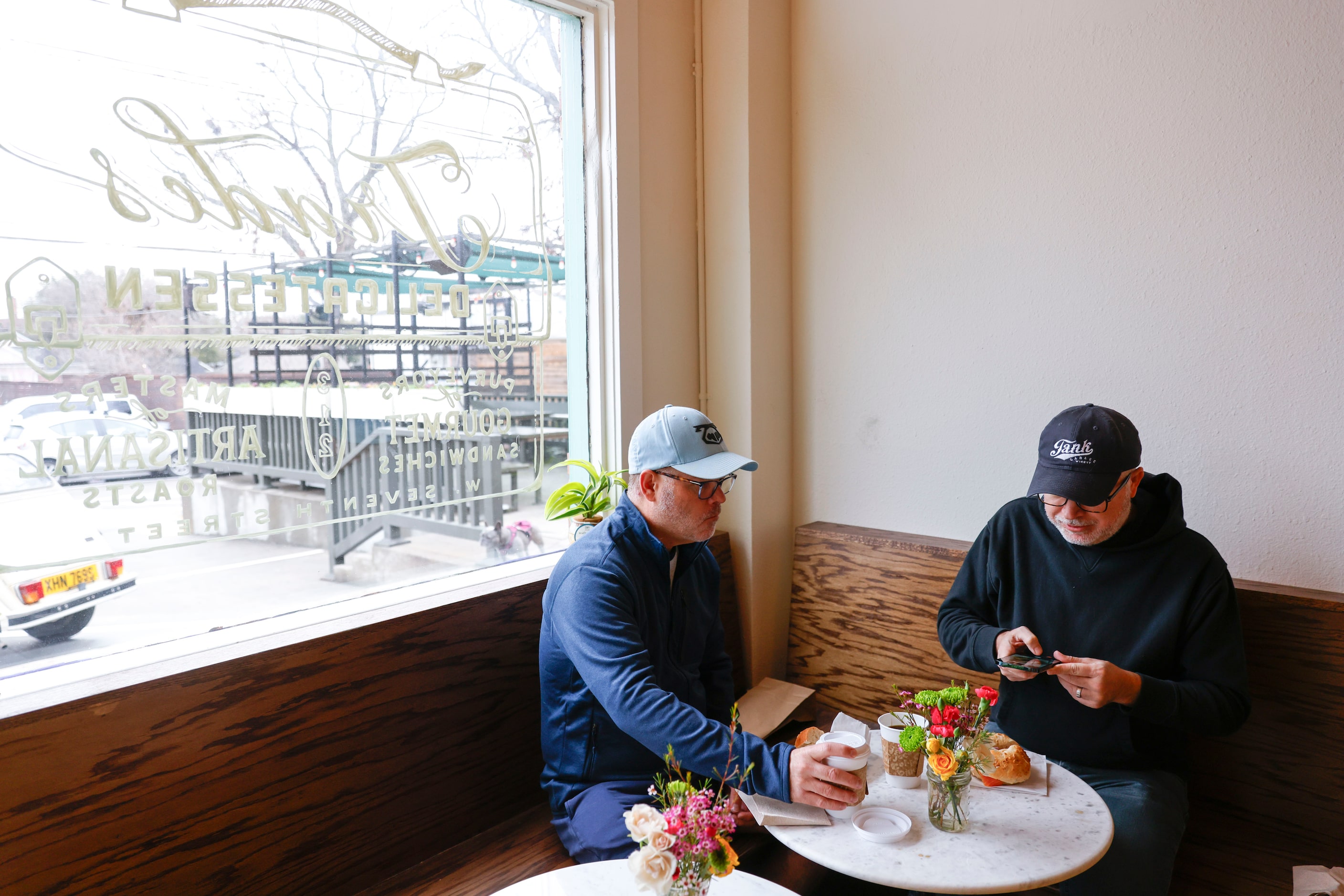 Tom Caraway (left) and Todd Johnson of Dallas sit with their bagels at Trades Delicatessen...