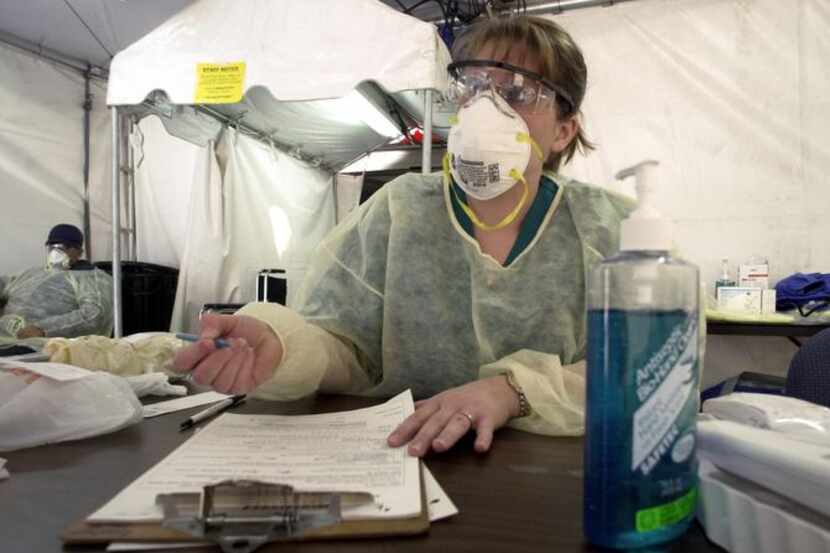 

 

In an outdoor triage tent, a nurse questioned a possible patient about SARS symptoms...
