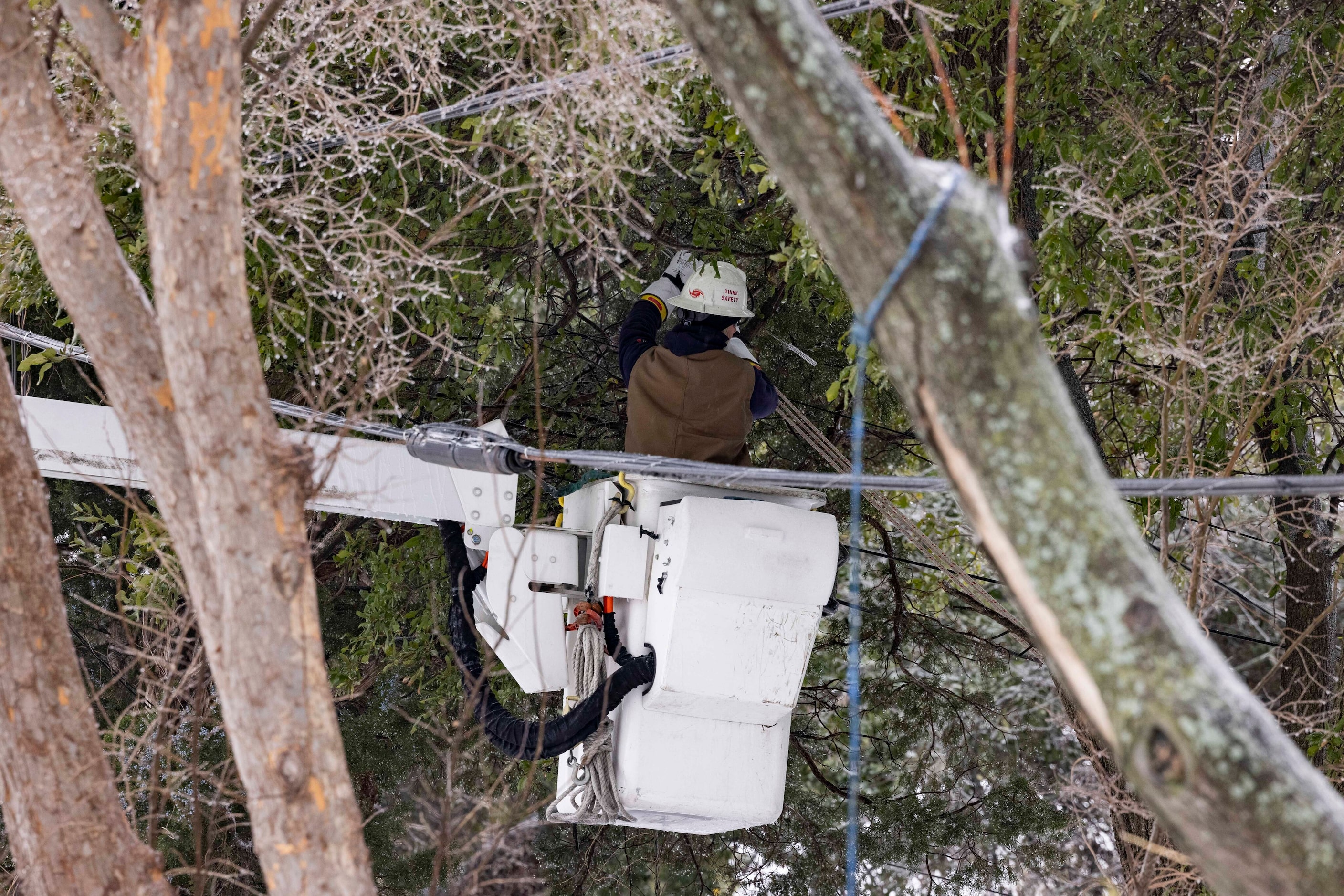 An Oncor technician works on a power line close to the intersection of W Illinois Ave and S...