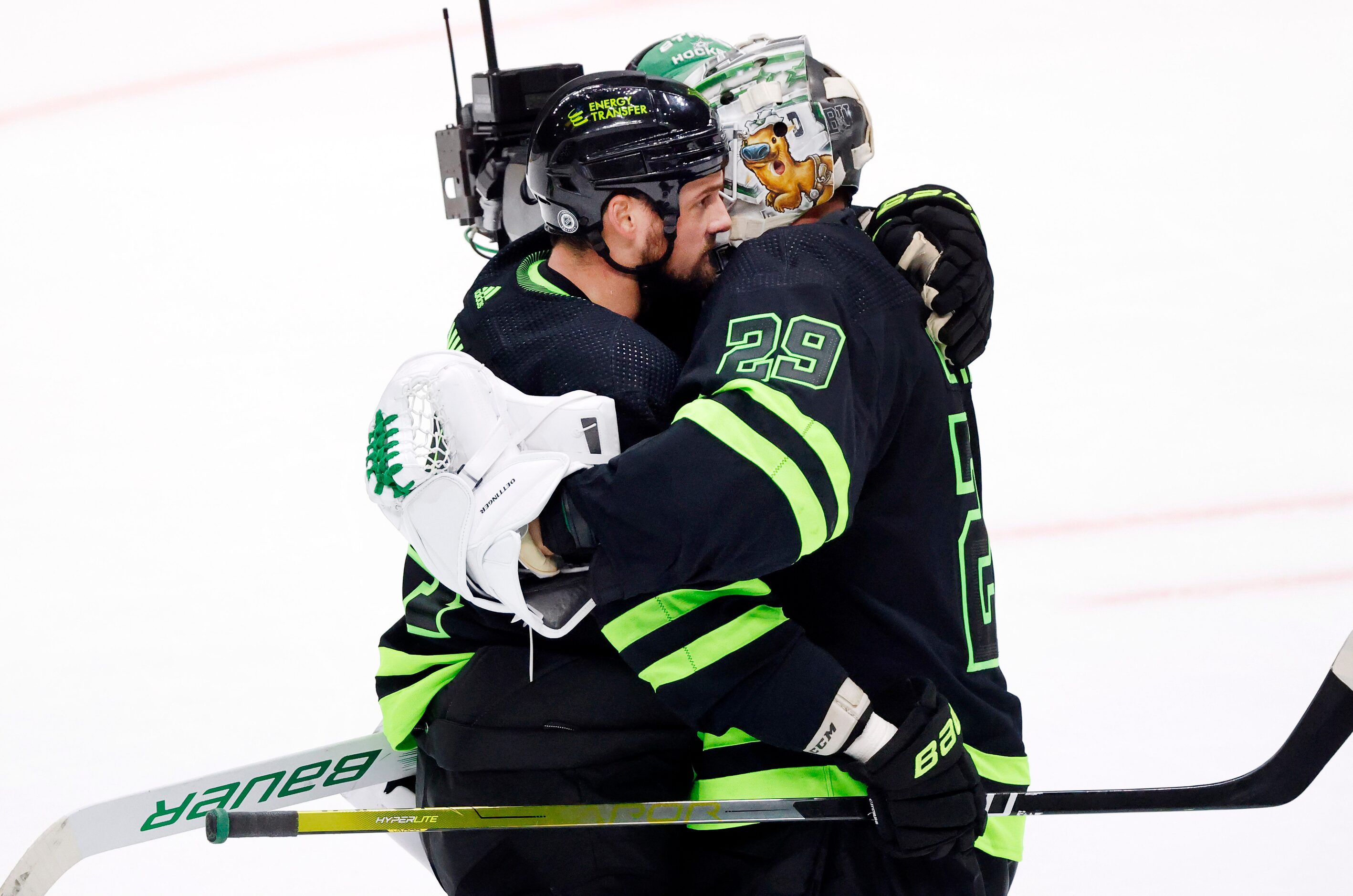 Dallas Stars goaltender Jake Oettinger (29) receives  a hug from Jamie Benn (14) after his...