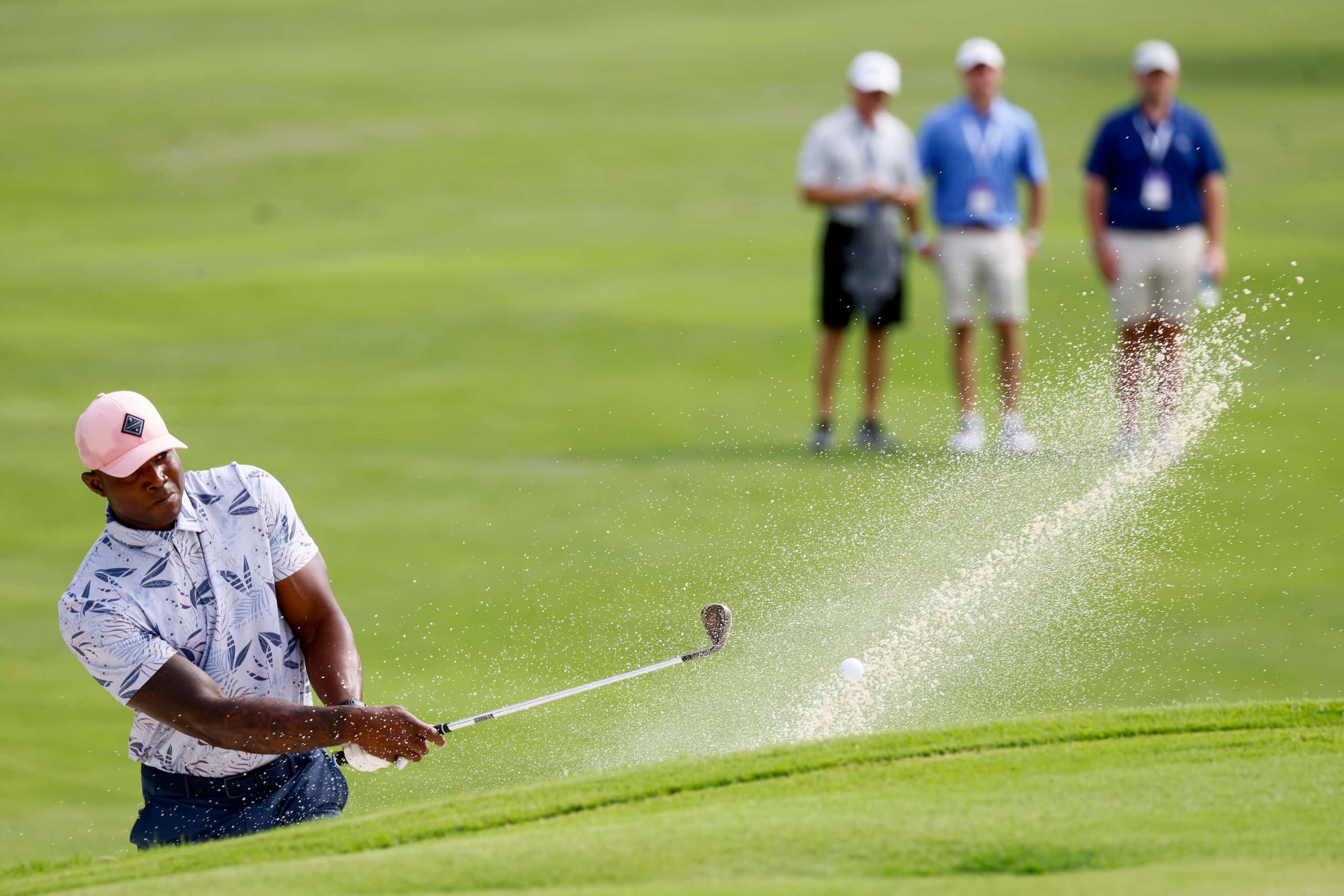 Former Dallas Cowboys player DeMarcus Ware plays out of a bunker onto the 14th green during...