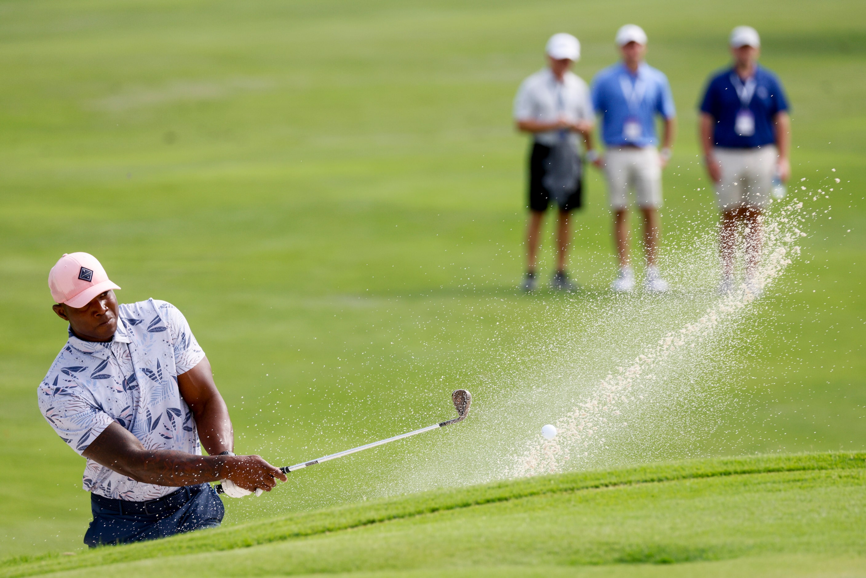 Former Dallas Cowboys player DeMarcus Ware plays out of a bunker onto the 14th green during...