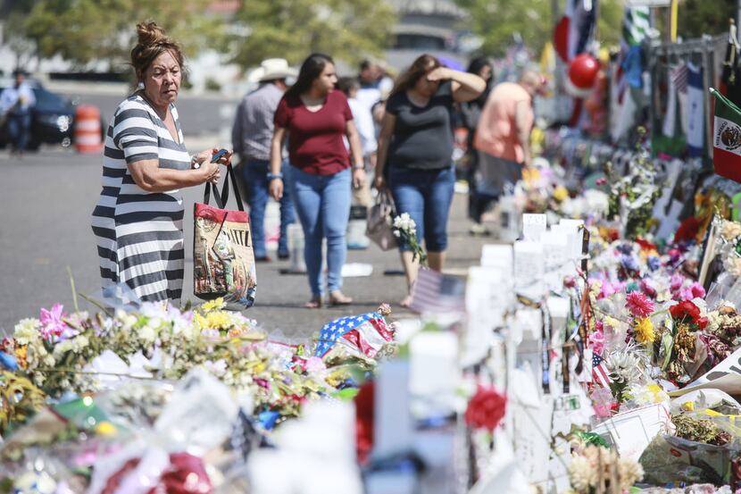 People gather at a makeshift memorial honoring victims outside Walmart in El Paso, Texas. 