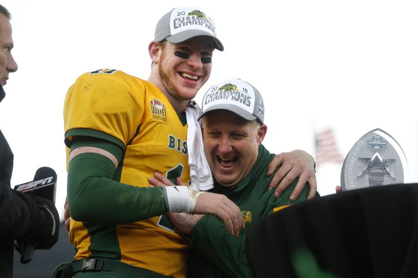 North Dakota State Bison head coach Chris Klieman (right) hugs quarterback Carson Wentz (11)...