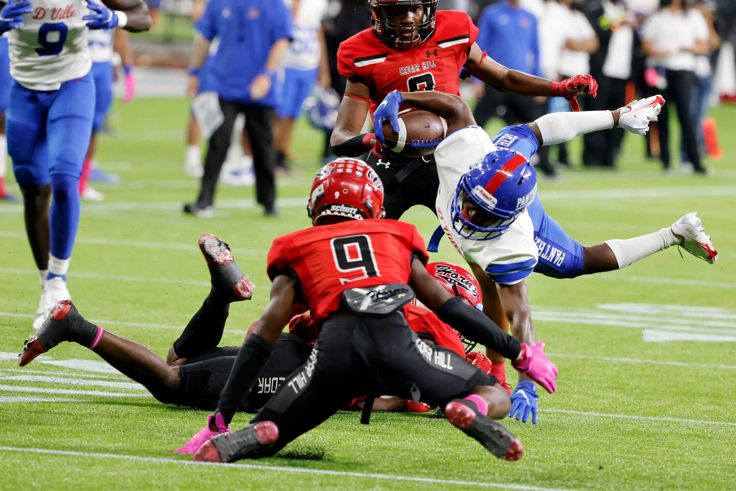 Duncanville’s Jayvyn Square (21) is upended by Cedar Hill defender Keandre Jackson (0) and...