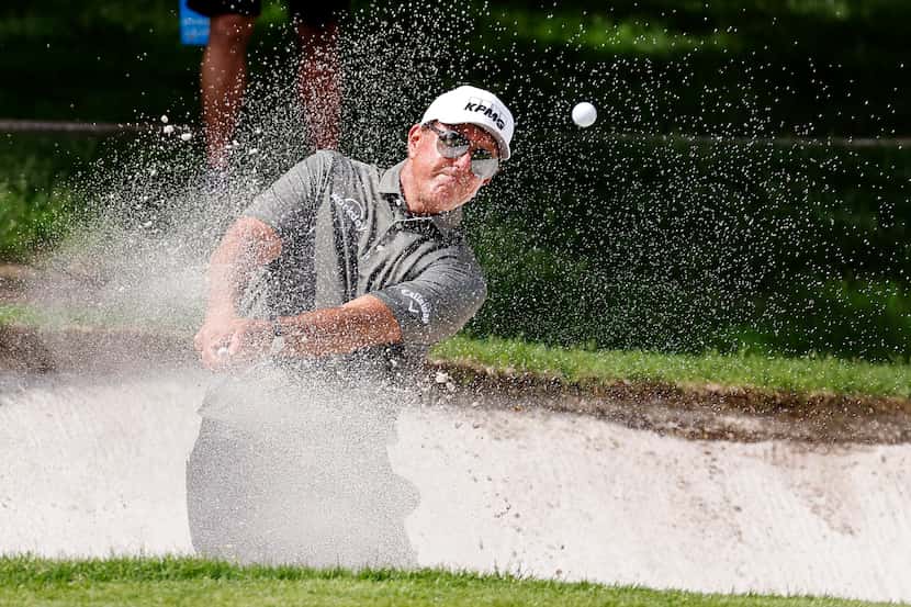 Professional golfer Phil Mickelson hits out of the green side bunker on No.1 during round...