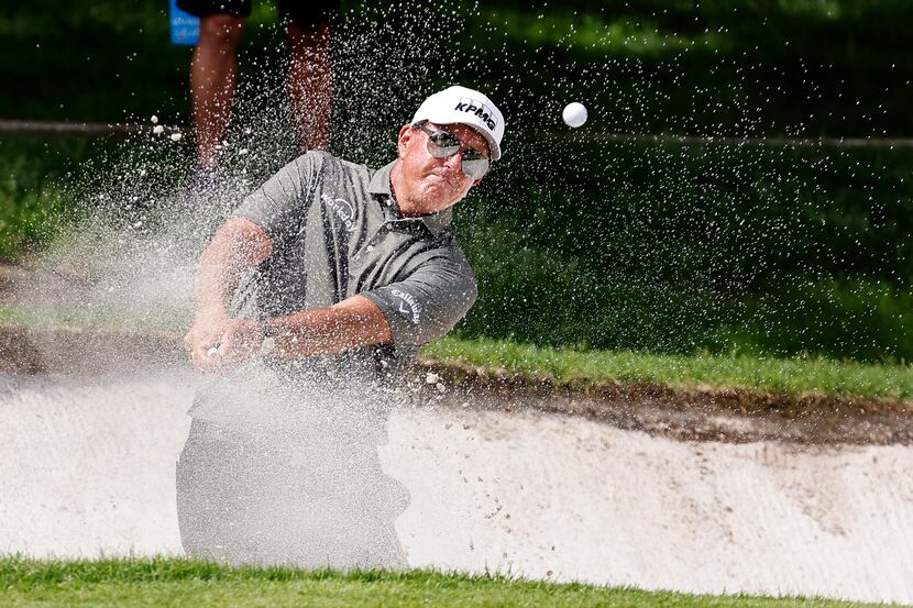 Professional golfer Phil Mickelson hits out of the green side bunker on No.1 during round...