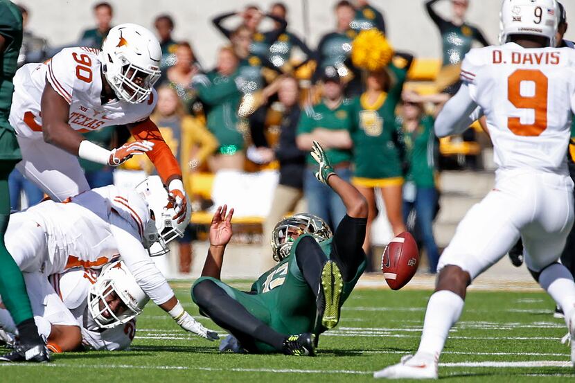 Baylor quarterback Chris Johnson (13) fumbles the ball after being hit by Texas cornerback...
