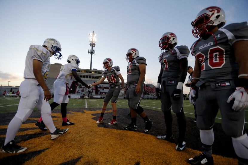 TXHSFB Conrad, left, and Woodrow Wilson captains shake hands before the first half of a high...