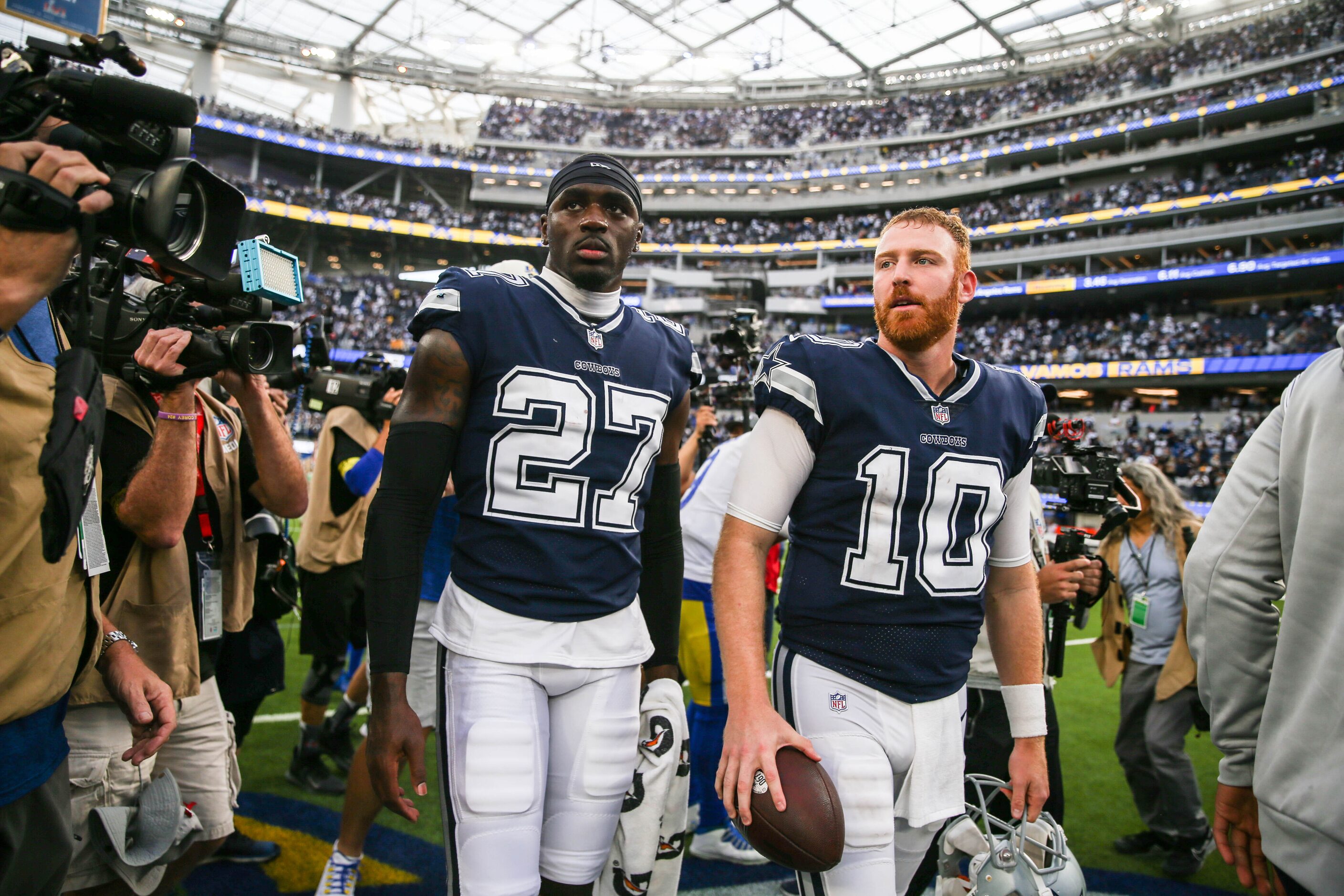 Dallas Cowboys quarterback Cooper Rush (10) and safety Jayron Kearse (27) walk on the field...