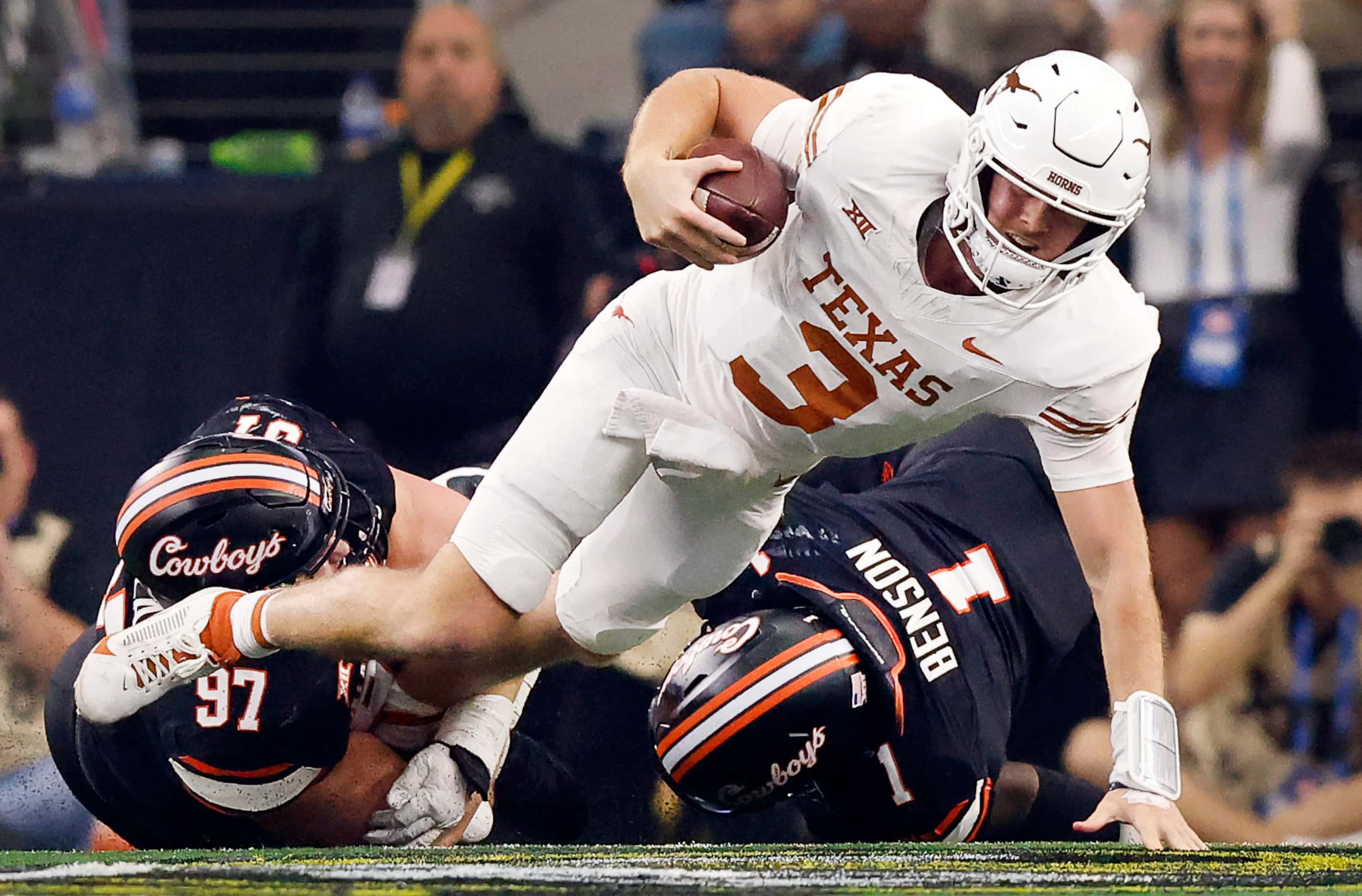 Texas Longhorns quarterback Quinn Ewers (3) is tripped by Oklahoma State Cowboys nose tackle...