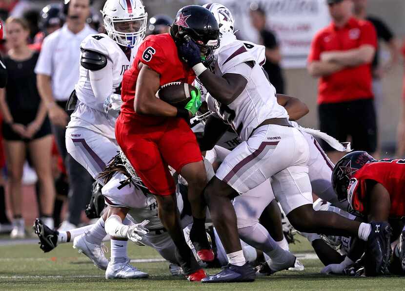 Coppell running back O'Marion Mbakwe (6) is stop by Lewisville linebacker Mark Cooper (12)...