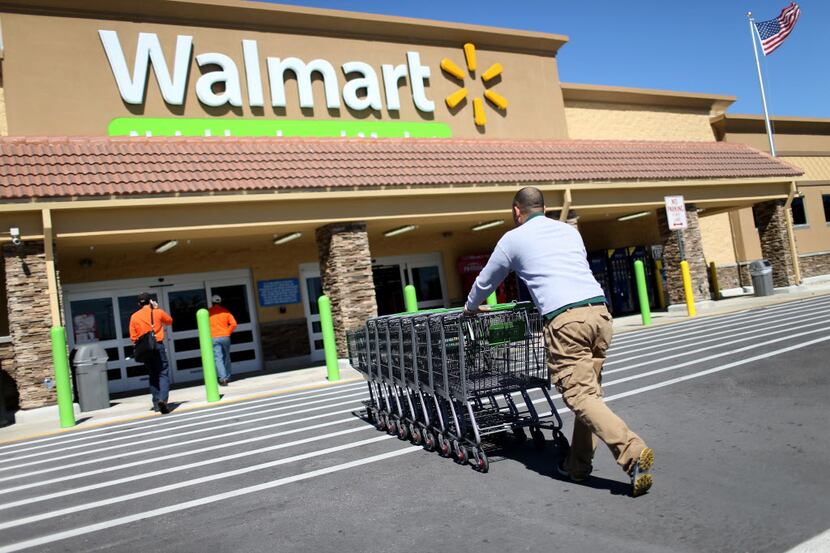 Wal-Mart employee Yurdin Velazquez pushes grocery carts toward theÂ store. Wal-Mart had...